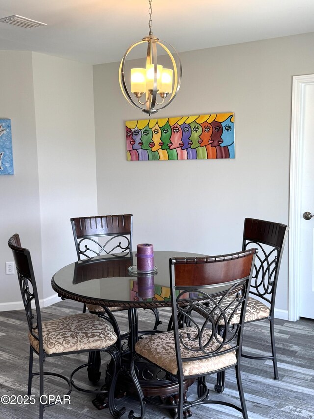 dining room featuring visible vents, baseboards, and wood finished floors