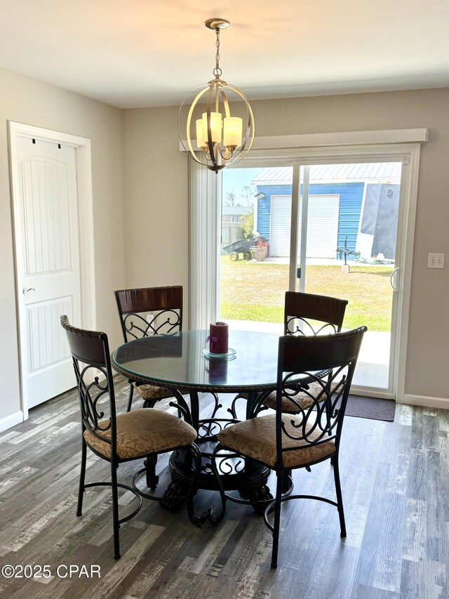 dining area with a chandelier, baseboards, and wood finished floors