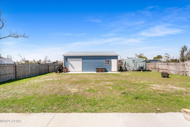 view of yard featuring a fire pit, an outdoor structure, and a fenced backyard