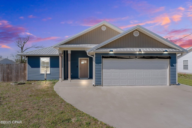 single story home featuring a garage, concrete driveway, metal roof, a standing seam roof, and fence