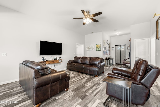 living area featuring ceiling fan, baseboards, and wood finished floors