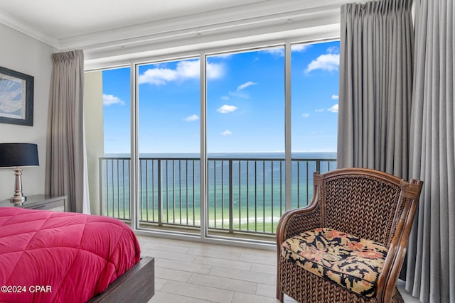 bedroom featuring a water view, expansive windows, multiple windows, and ornamental molding