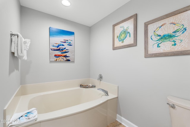 full bathroom featuring toilet, a garden tub, and baseboards