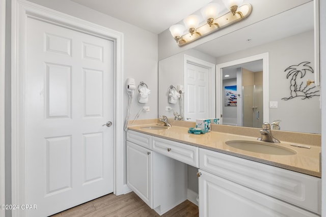 bathroom featuring double vanity, wood finished floors, and a sink