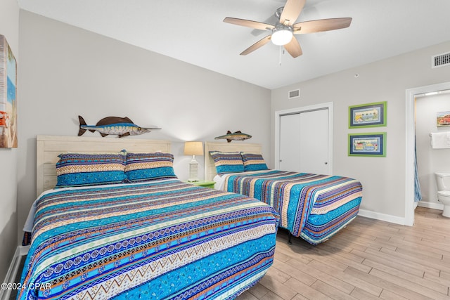 bedroom with a closet, visible vents, a ceiling fan, wood finished floors, and baseboards