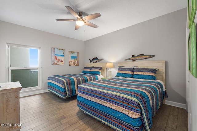 bedroom featuring ceiling fan, baseboards, and wood finished floors