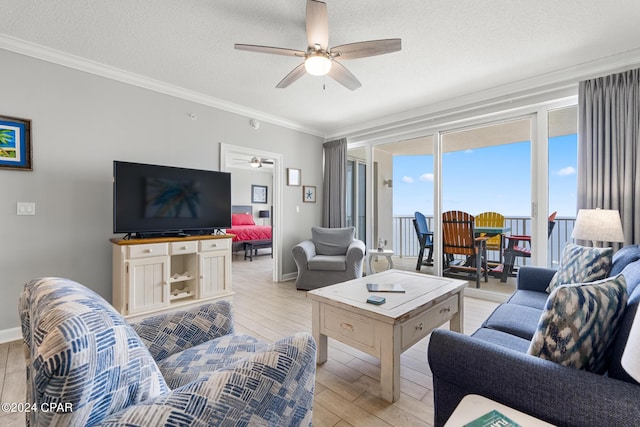 living area featuring crown molding, light wood-style flooring, ceiling fan, a textured ceiling, and baseboards