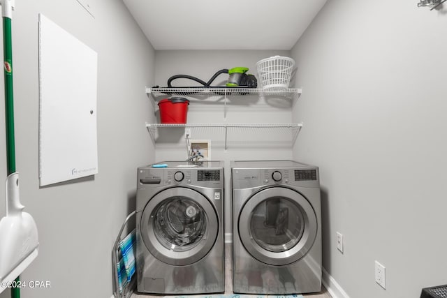 clothes washing area with laundry area, washer and dryer, and baseboards
