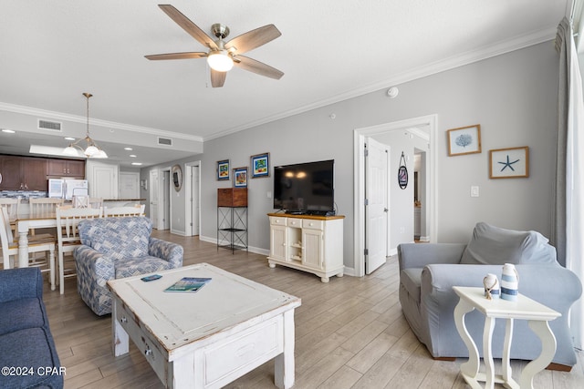 living area with light wood-style floors, visible vents, crown molding, and ceiling fan