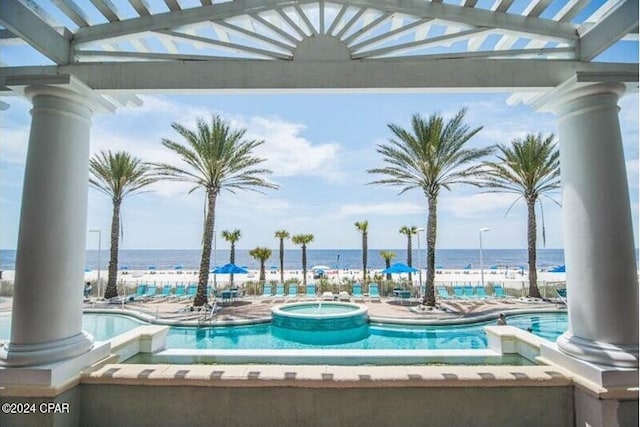 pool with a water view and a hot tub