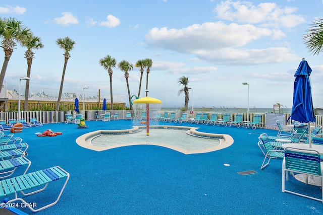 view of swimming pool featuring fence