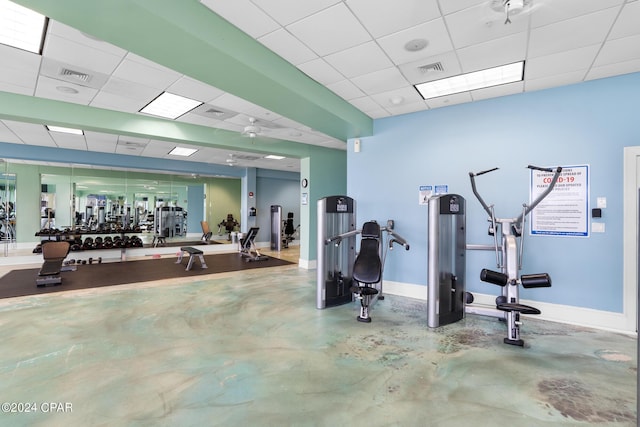 workout area with baseboards, visible vents, and a drop ceiling