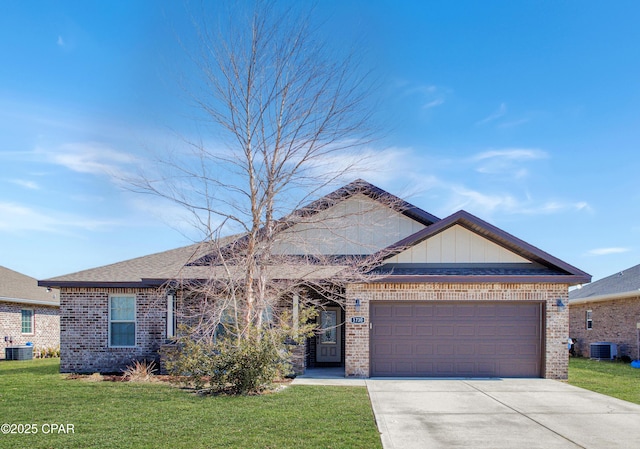 view of front of house featuring central AC unit, a garage, brick siding, driveway, and a front yard