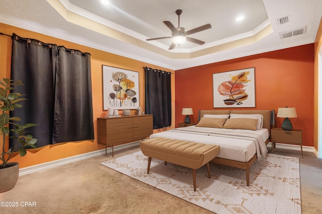 carpeted bedroom with ornamental molding, a raised ceiling, and visible vents