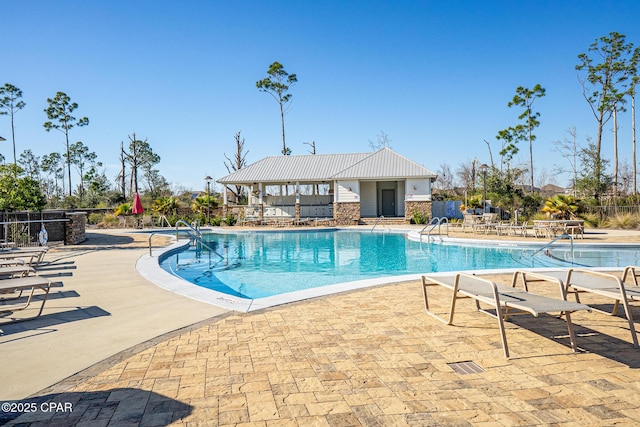 pool with a patio area and fence
