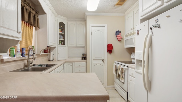 kitchen featuring white appliances, visible vents, light countertops, a textured ceiling, and a sink