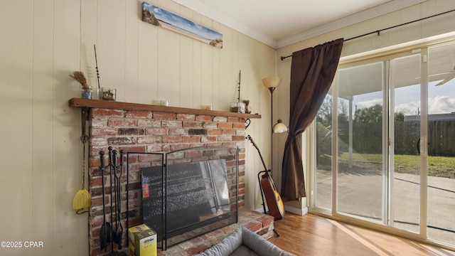 unfurnished living room with ornamental molding, a brick fireplace, and wood finished floors