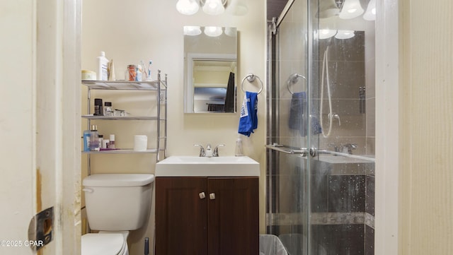 full bathroom featuring toilet, a shower stall, and vanity