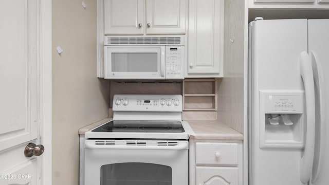 kitchen featuring white cabinetry, light countertops, and white appliances