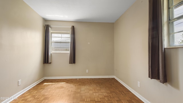 spare room with baseboards and a healthy amount of sunlight