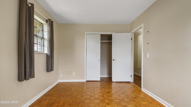 unfurnished bedroom with baseboards and a closet