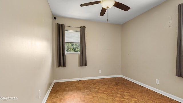spare room with a ceiling fan and baseboards