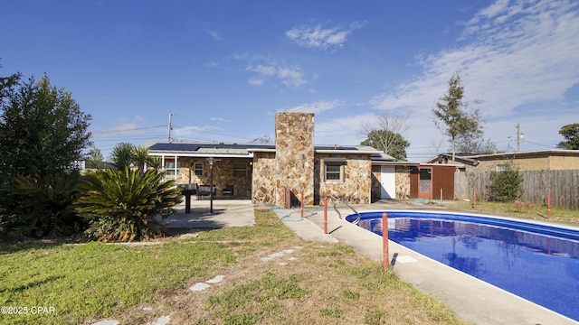 view of swimming pool featuring a lawn, fence, a fenced in pool, and a patio