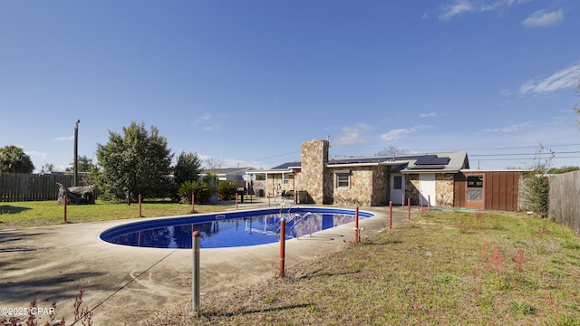 view of swimming pool with a fenced in pool, a patio area, a fenced backyard, and a lawn