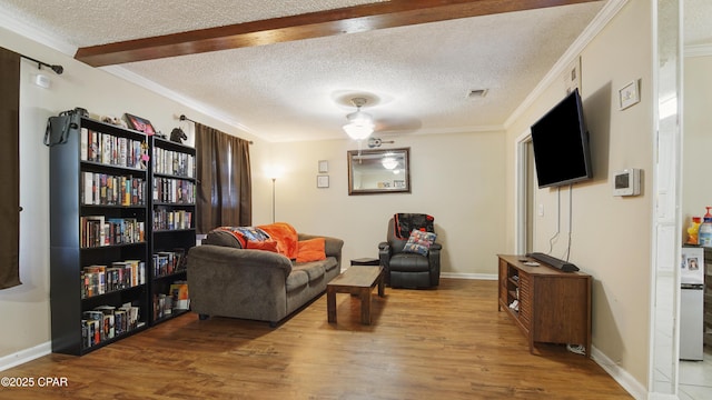 sitting room with visible vents, crown molding, a textured ceiling, and wood finished floors