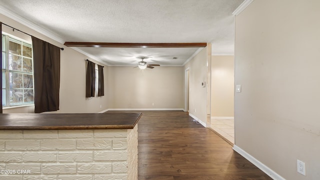 interior space with wood finished floors, ornamental molding, and a ceiling fan