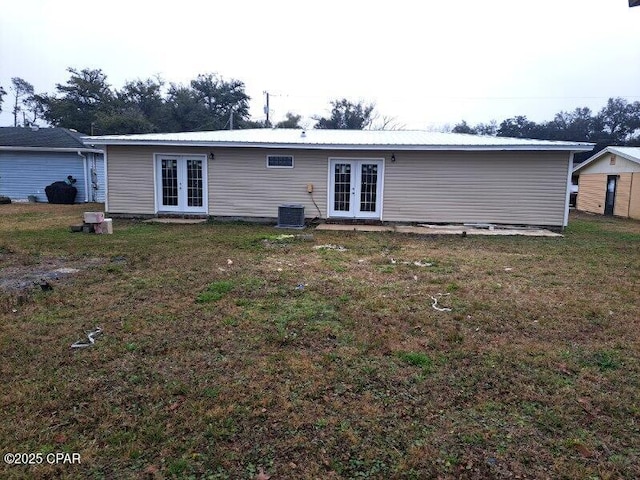 back of house with cooling unit, french doors, a yard, and metal roof