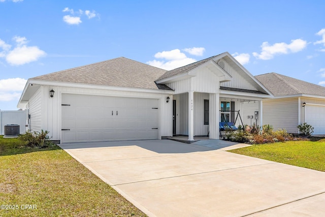 single story home with an attached garage, board and batten siding, a front yard, and central air condition unit