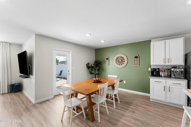 dining area with light wood-style flooring and baseboards