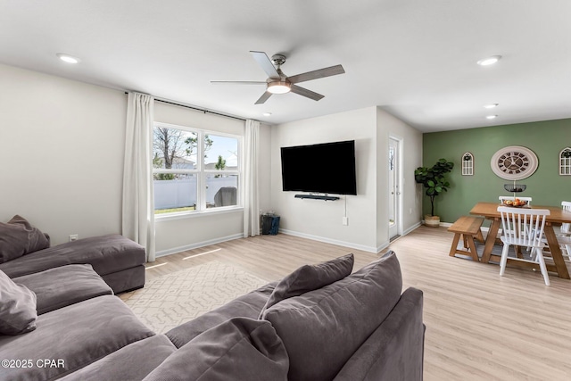 living area with a ceiling fan, recessed lighting, light wood-style flooring, and baseboards