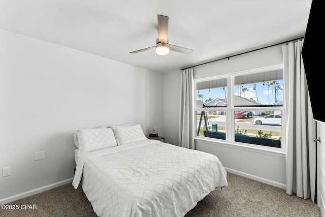 carpeted bedroom with ceiling fan and baseboards