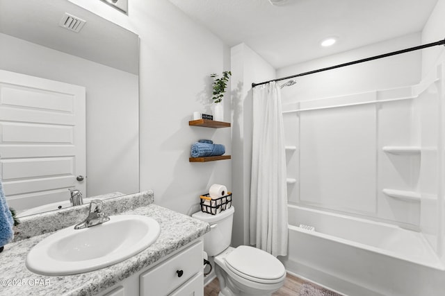 bathroom featuring toilet, shower / tub combo, wood finished floors, vanity, and visible vents