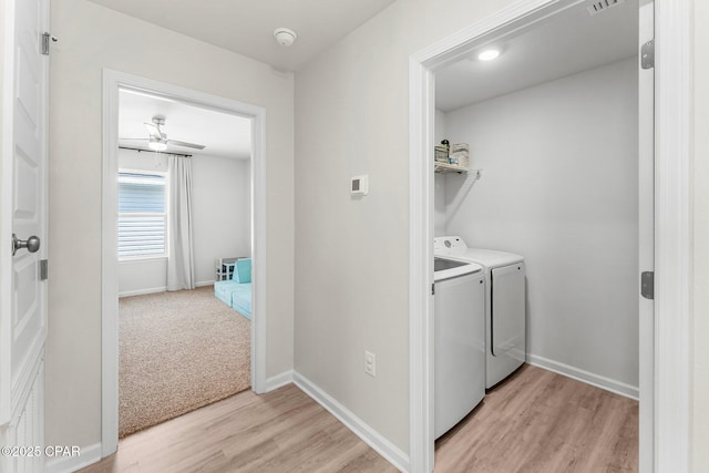 clothes washing area featuring washer and clothes dryer, light wood finished floors, visible vents, laundry area, and baseboards