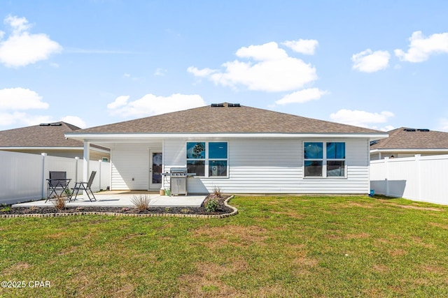 back of property with a patio, a lawn, fence, and roof with shingles