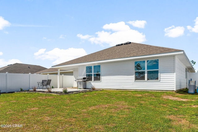 rear view of property with a patio, a yard, roof with shingles, and fence