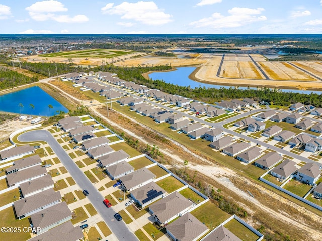 drone / aerial view featuring a water view and a residential view