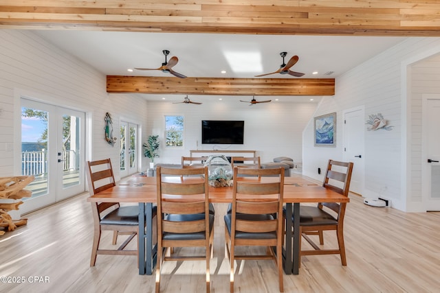 dining area featuring french doors, plenty of natural light, light wood finished floors, and beam ceiling