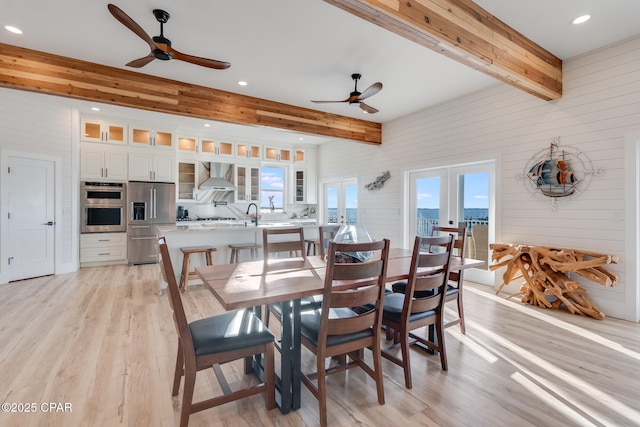 dining area with a ceiling fan, beamed ceiling, french doors, light wood-style floors, and recessed lighting