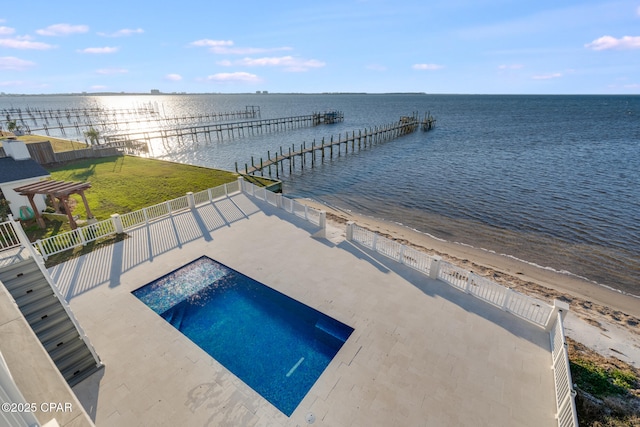 view of swimming pool with a view of the beach, a water view, and a dock