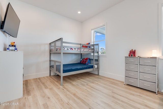 bedroom with recessed lighting, wood finished floors, and baseboards