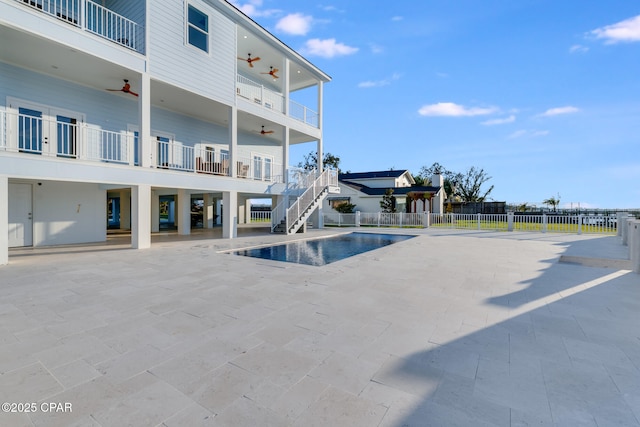 view of pool with a fenced in pool, a ceiling fan, a patio, stairs, and fence