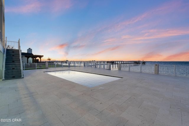 view of swimming pool featuring a water view and a patio area