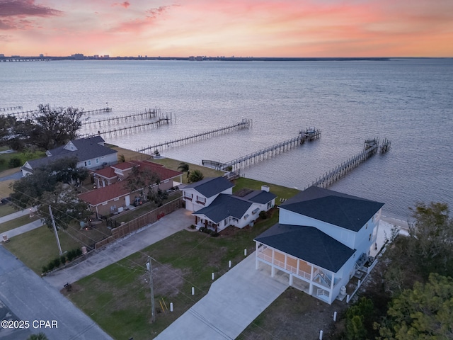 aerial view at dusk featuring a water view