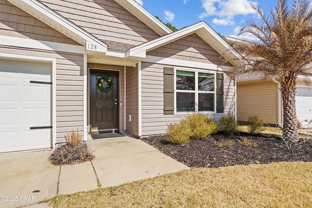 property entrance with a shingled roof and an attached garage