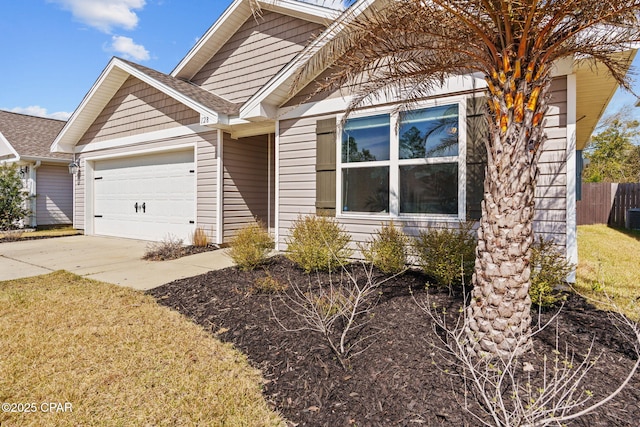 view of front of property featuring a garage, fence, concrete driveway, and roof with shingles