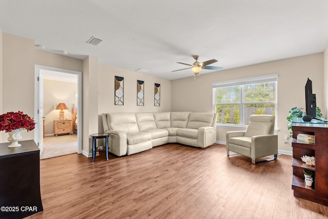 living area with light wood finished floors, visible vents, baseboards, and a ceiling fan